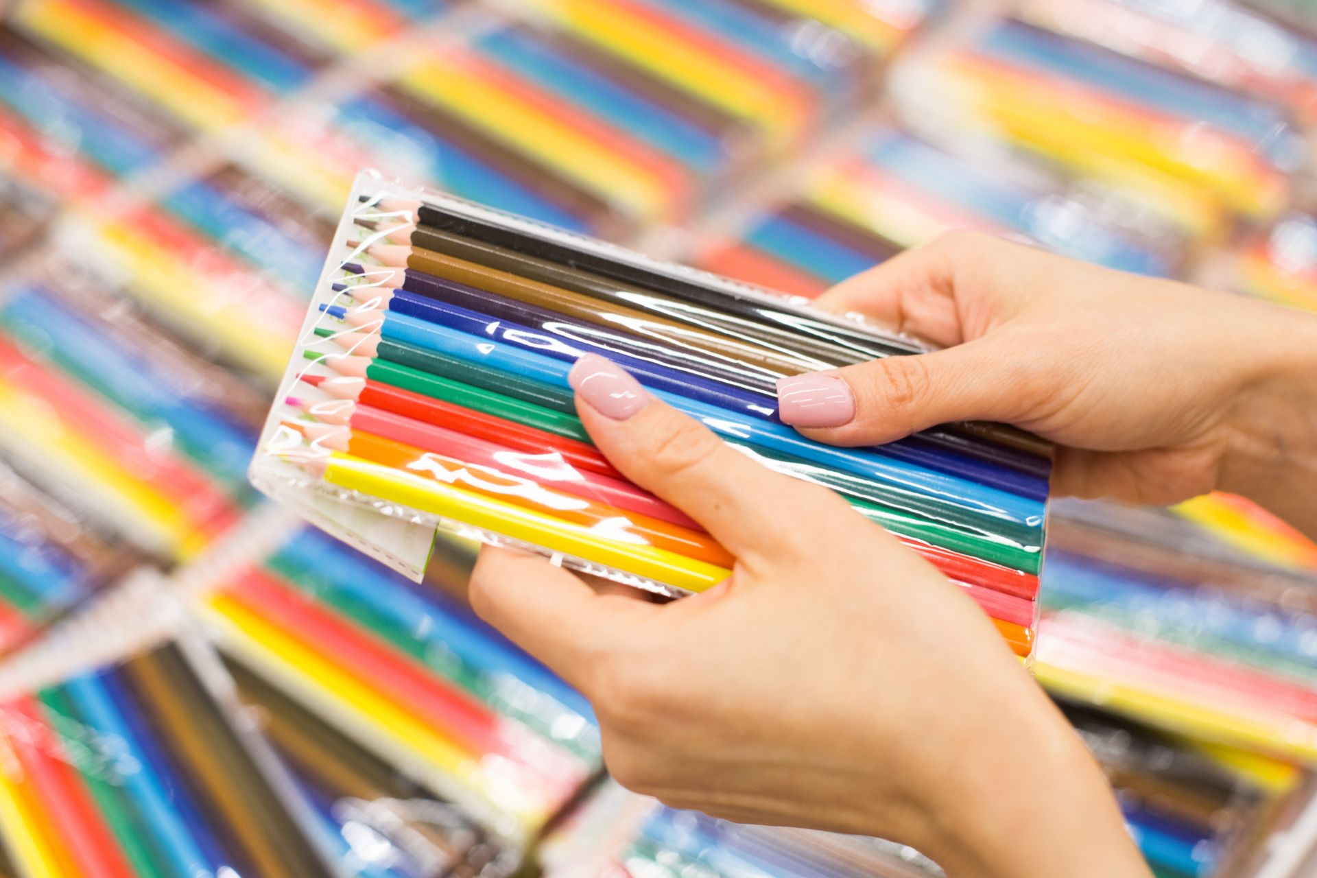 a-woman-chooses-colored-pencils-in-a-store-with-st-2023-11-27-05-04-54-utc